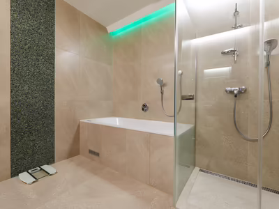 Badezimmer mit Badewanne und Dusche Deluxe Suite