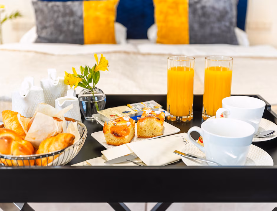 Frühstück mit Kaffee, Saft und Gebäck auf einem kleinen Tisch in der Suite