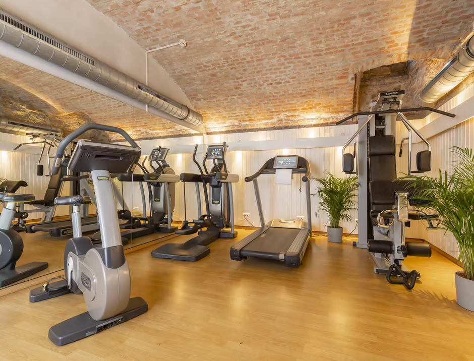 Fitnessstudio im Hilight Suites Hotel Heller Fitnessbereich mit verschiedenen Geräten