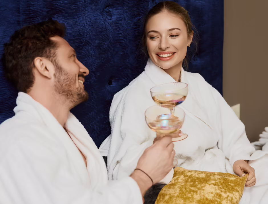 Entspannung in der Suite Paar sitzt gemeinsam auf einem Bett in einer Hotelsuite