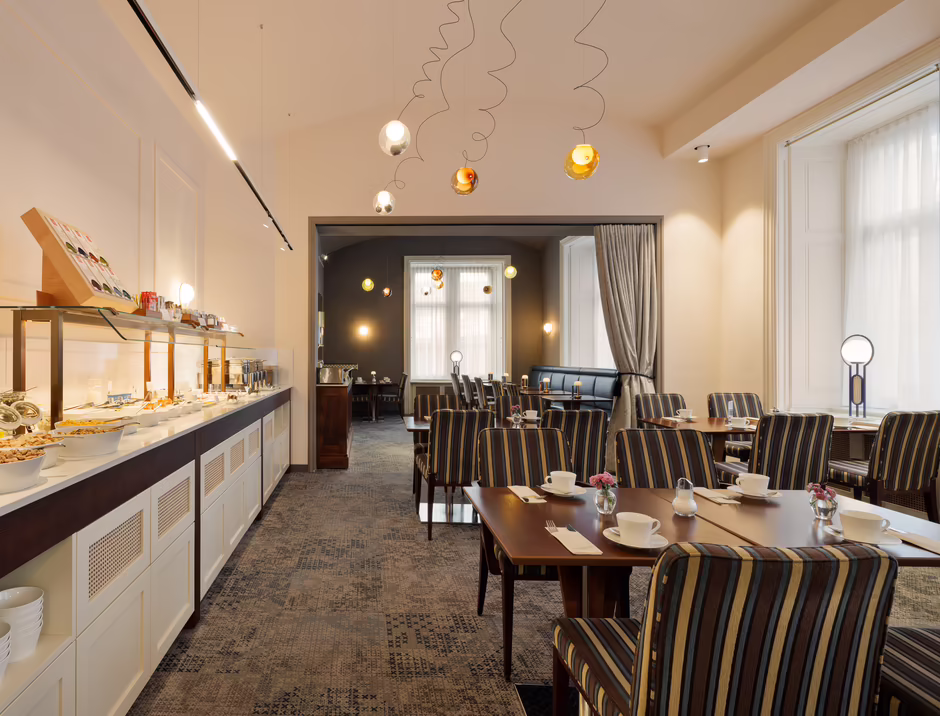 Heller Frühstücksraum mit gedeckten Tischen im HiLight Suites Hotel