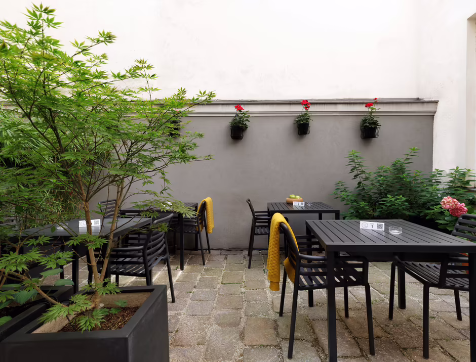 Begrünter Innenhof mit Sitzmöglichkeiten im HiLight Suites Hotel 
